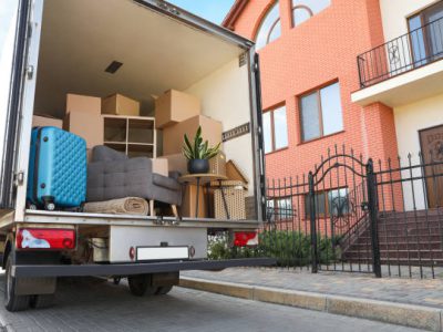 Van full of moving boxes and furniture near house